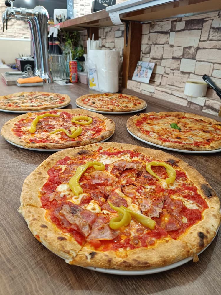 Frissen sült pizzák a Pinocchio pultján, a konyhából